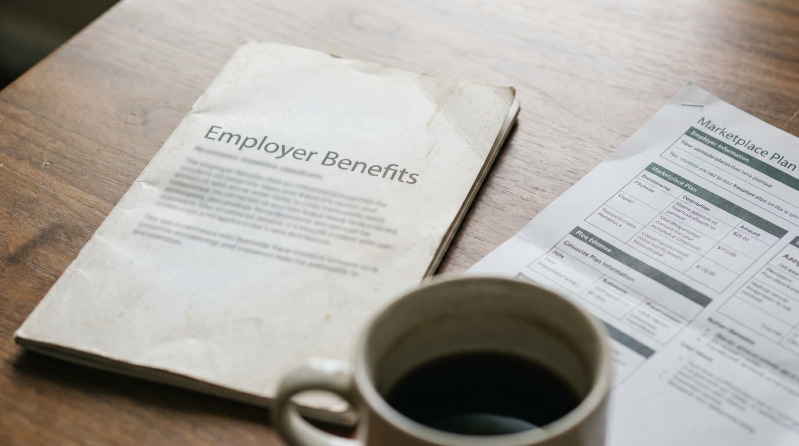 A balance scale weighing an employer building against a marketplace plan card